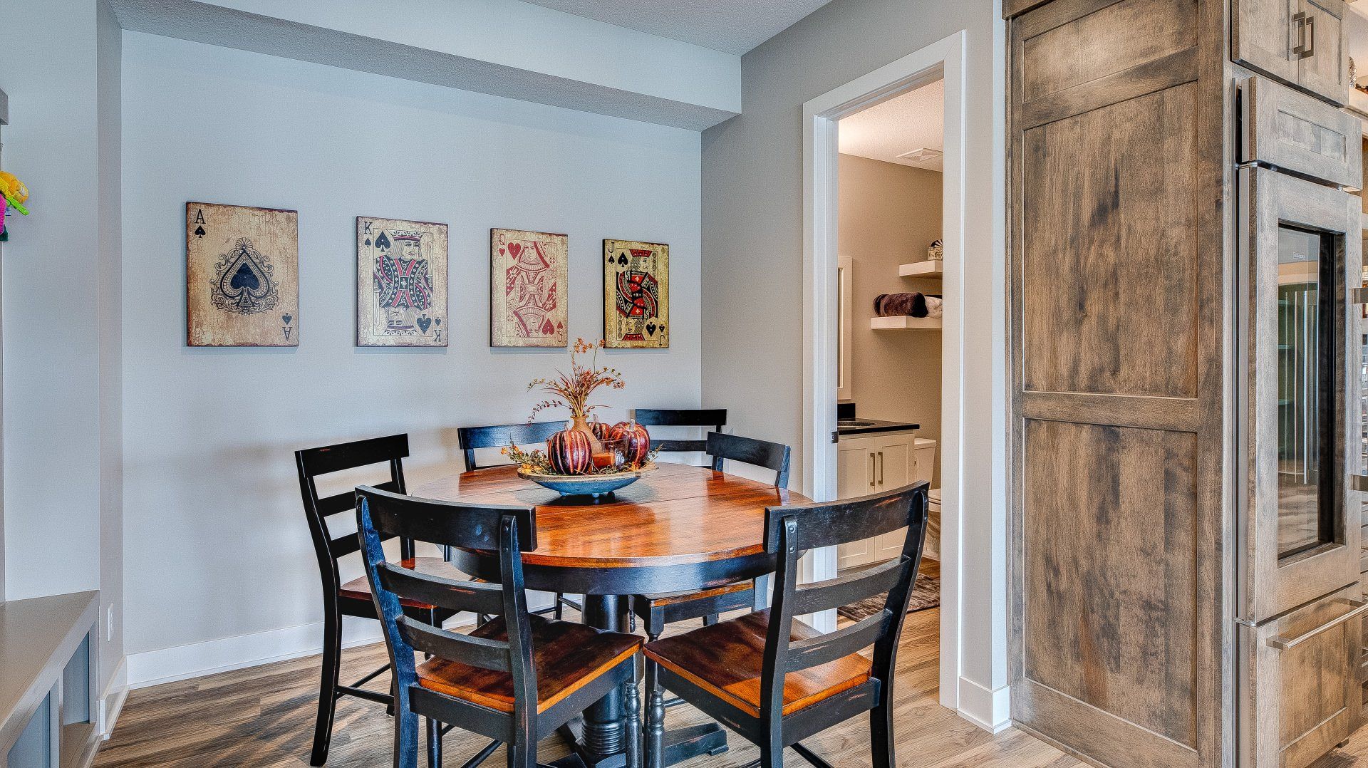 A dining room with a round table and chairs.