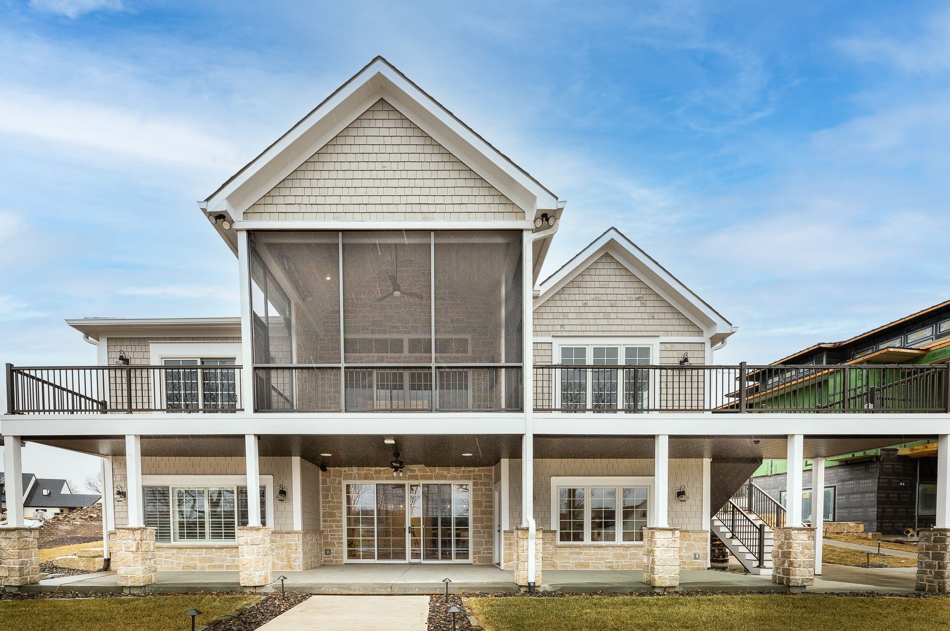 A large house with a screened in porch and a large deck.