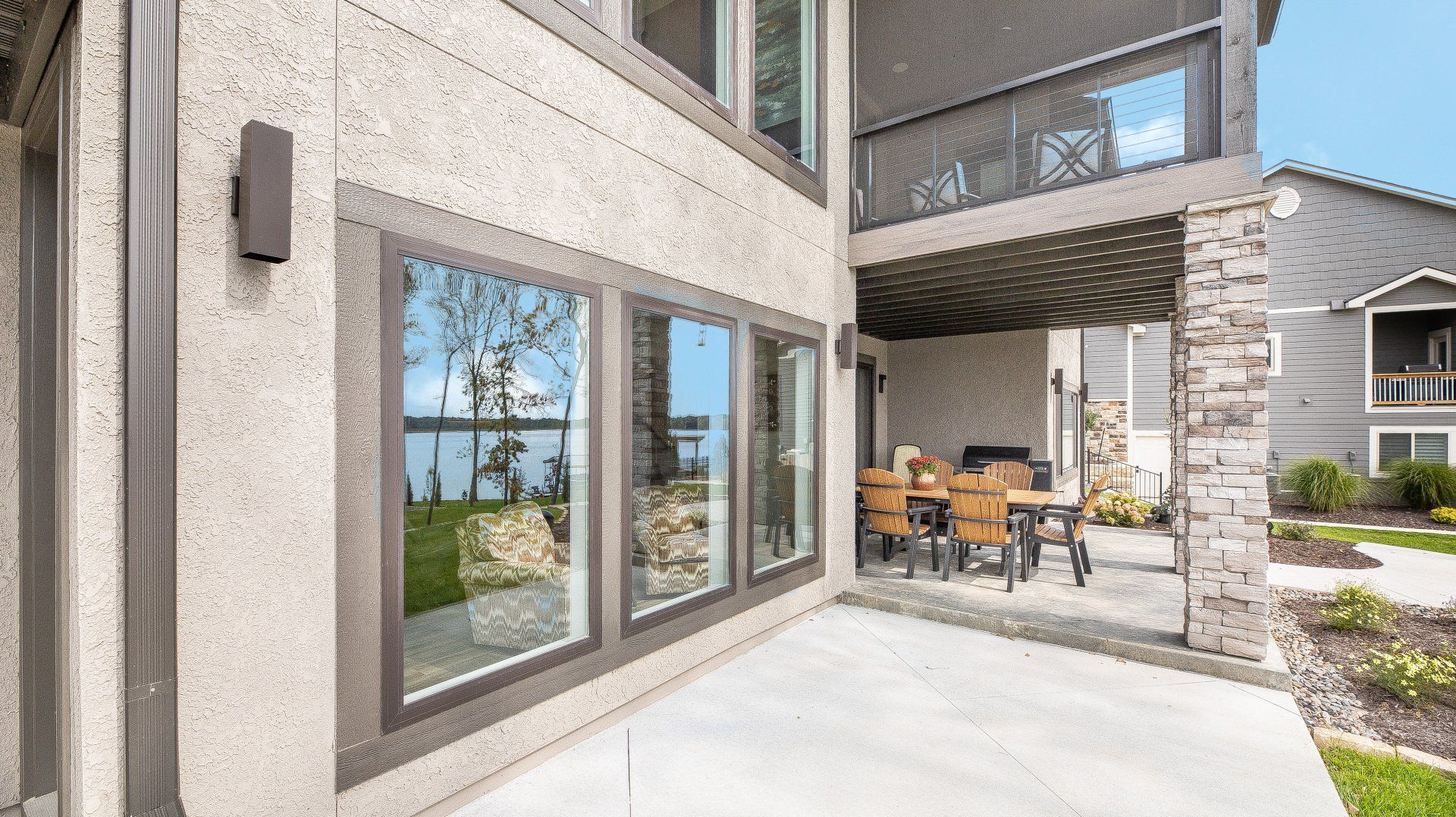 A large house with a patio and a lot of windows.