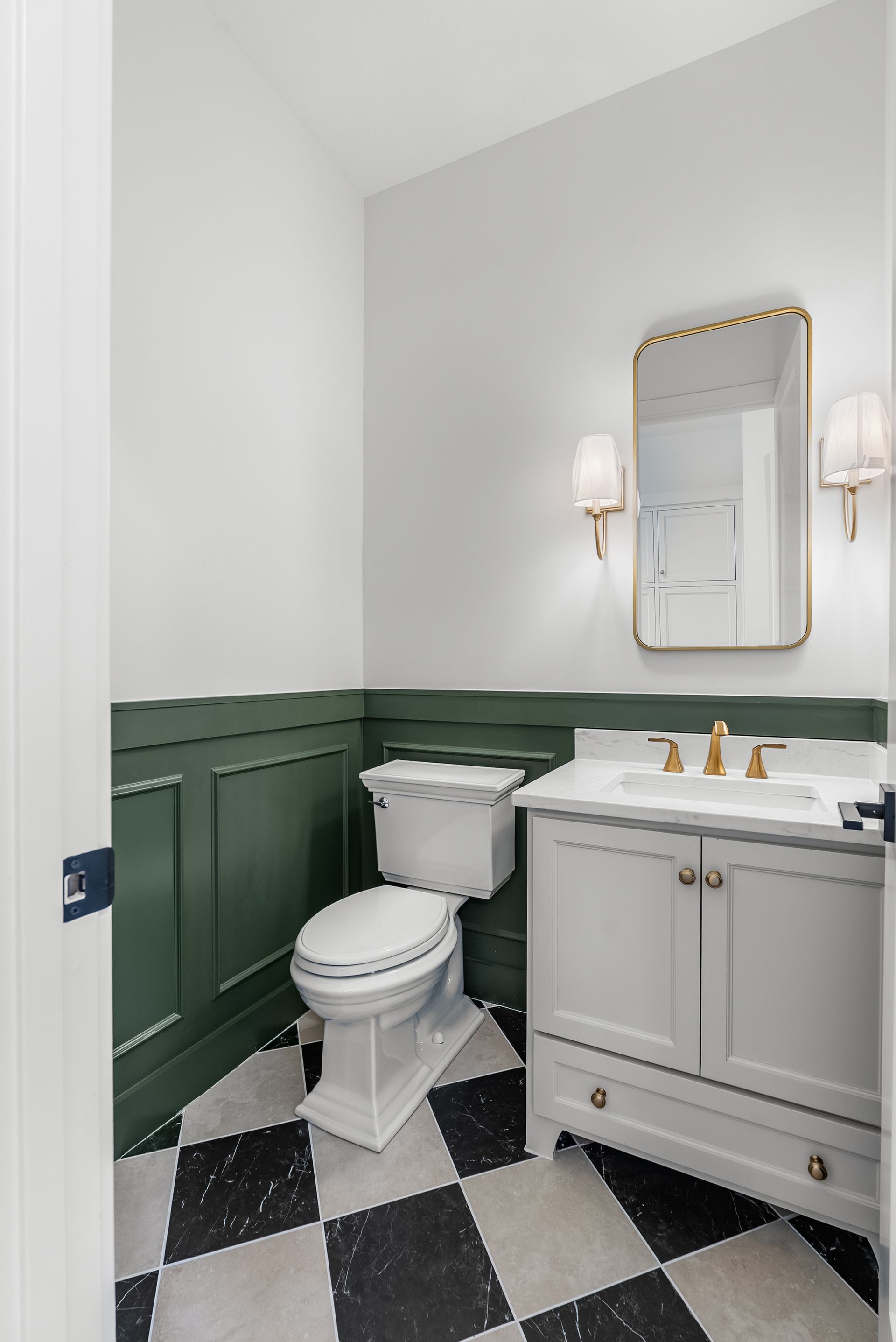 Powder room: white toilet, grey vanity, gold mirror, green wainscoting, black/white checkered floor.