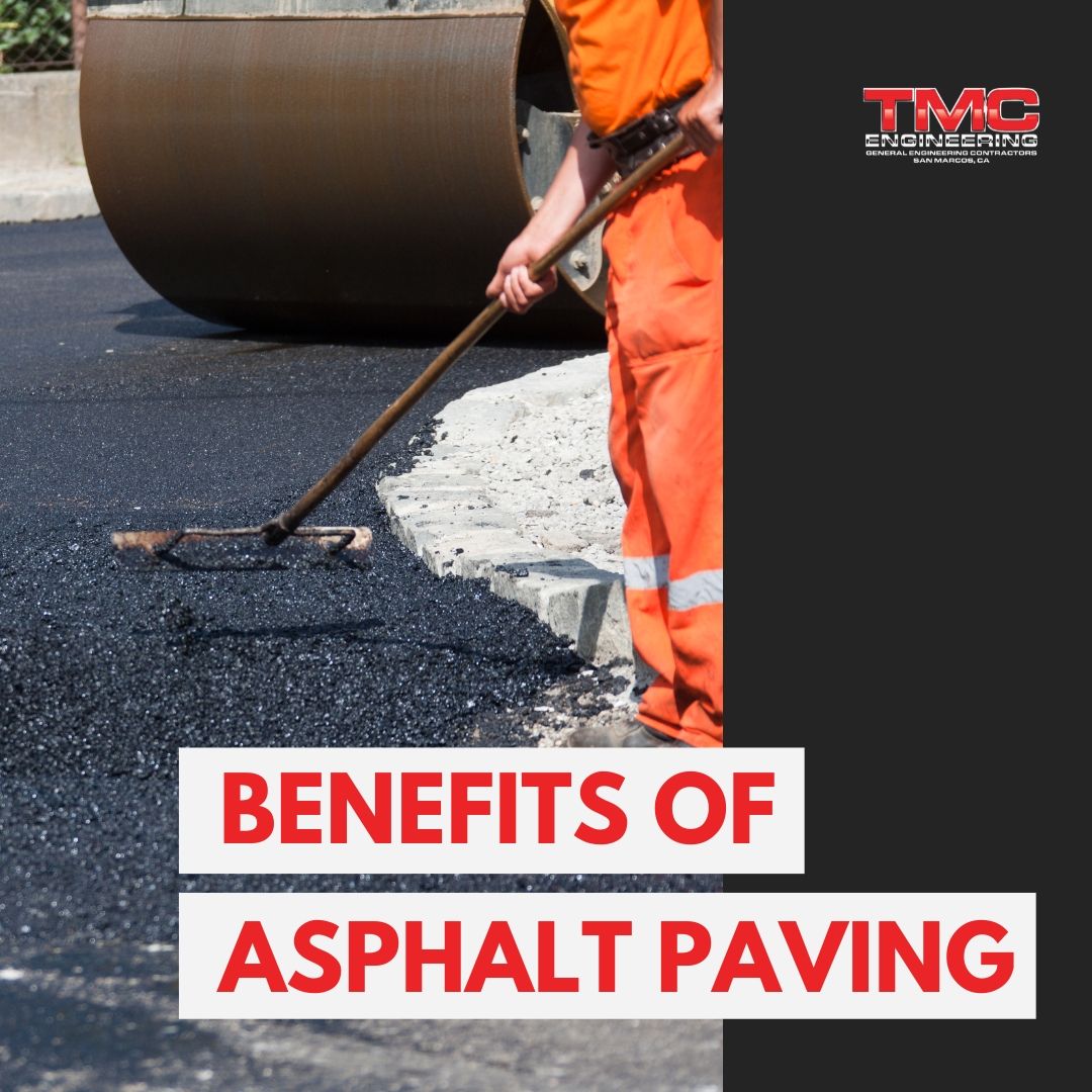 A man is spreading asphalt on a road with a broom.