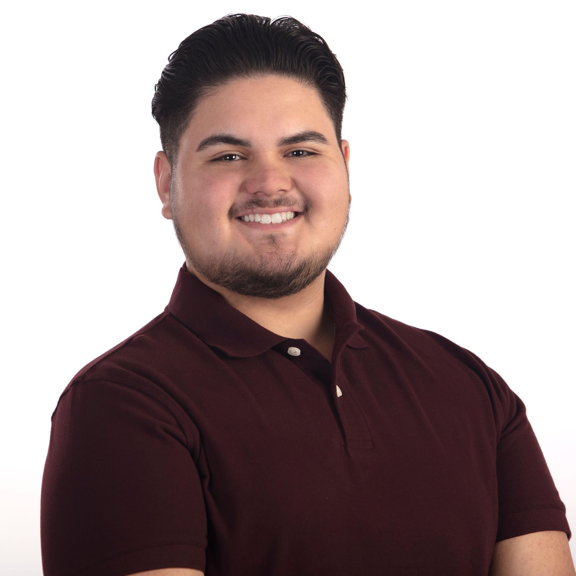 A man in a maroon polo shirt is smiling for the camera