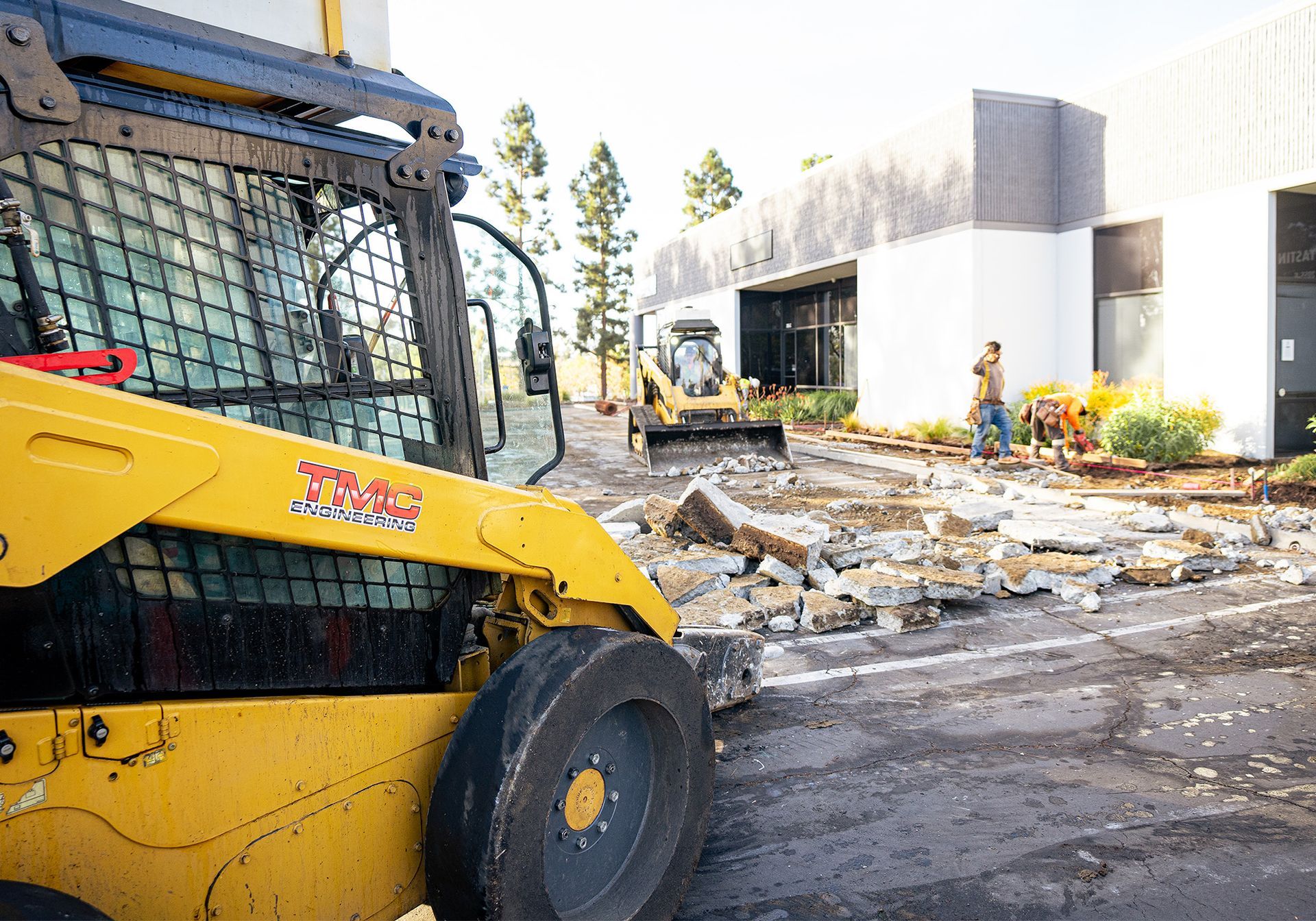 A yellow bulldozer is being used to demolish sidewalk.