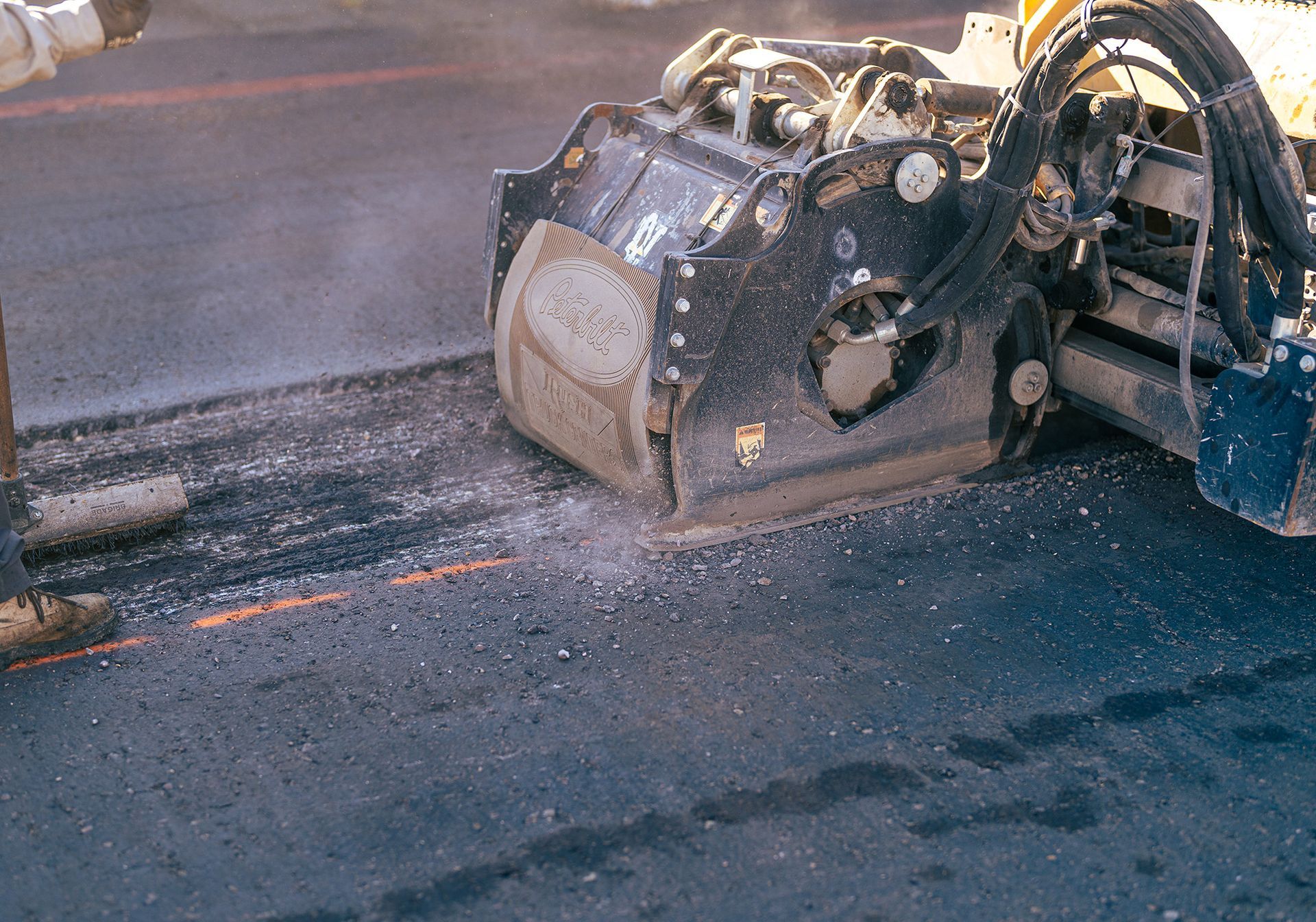 A machine is being used to grind asphalt on a road