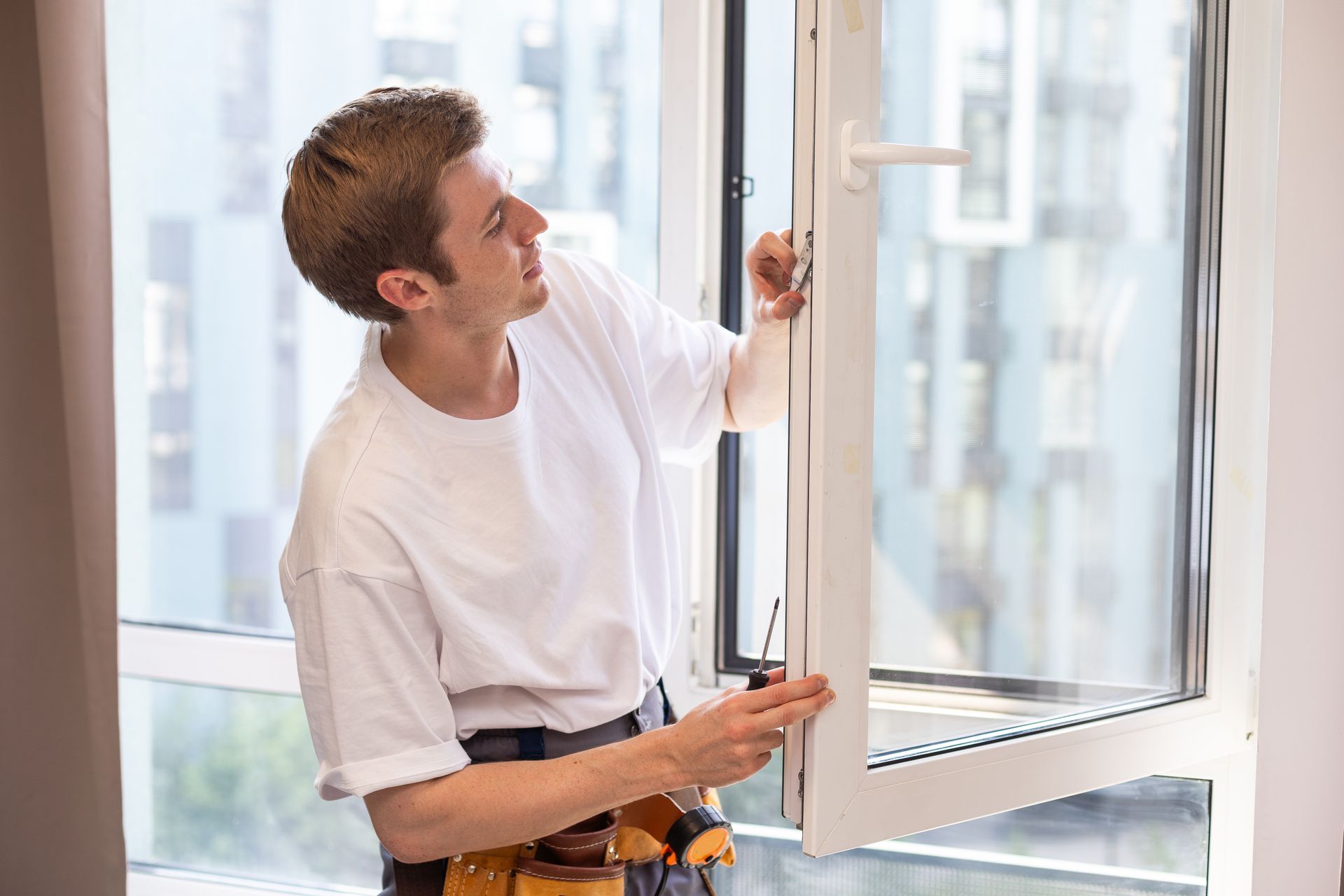 A window repairman installs a double-glazed window in an apartment
