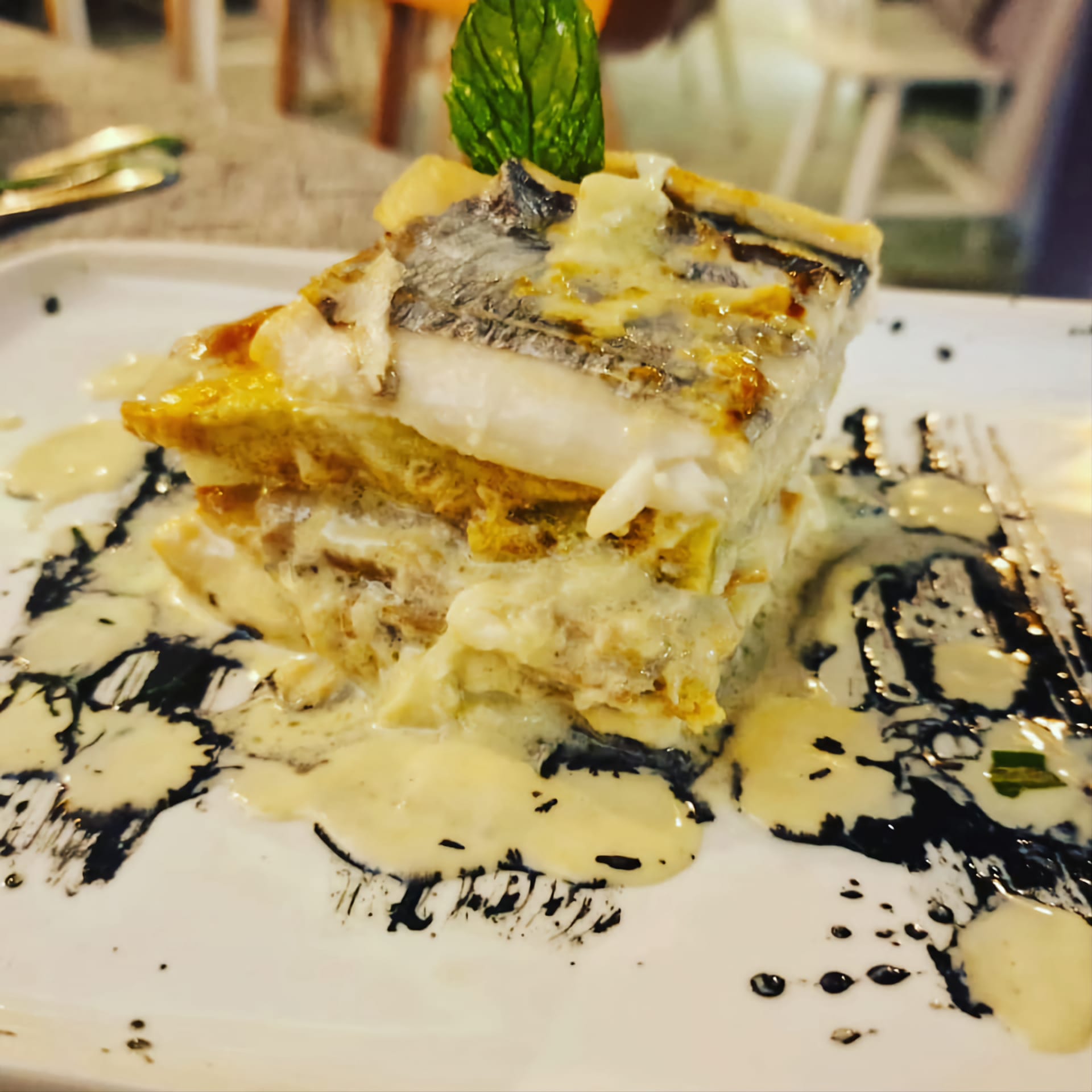 Un piatto bianco sormontato da un pezzo di cibo e salsa