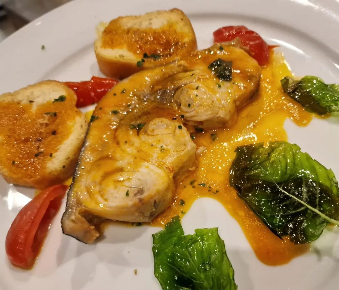 Un piatto di cibo con pomodori e lattuga sopra