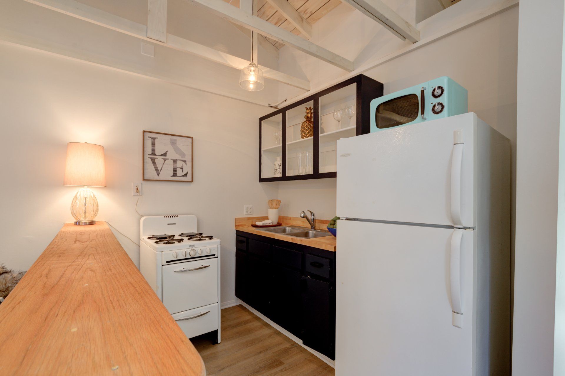 A kitchen with a refrigerator , stove , sink and microwave.