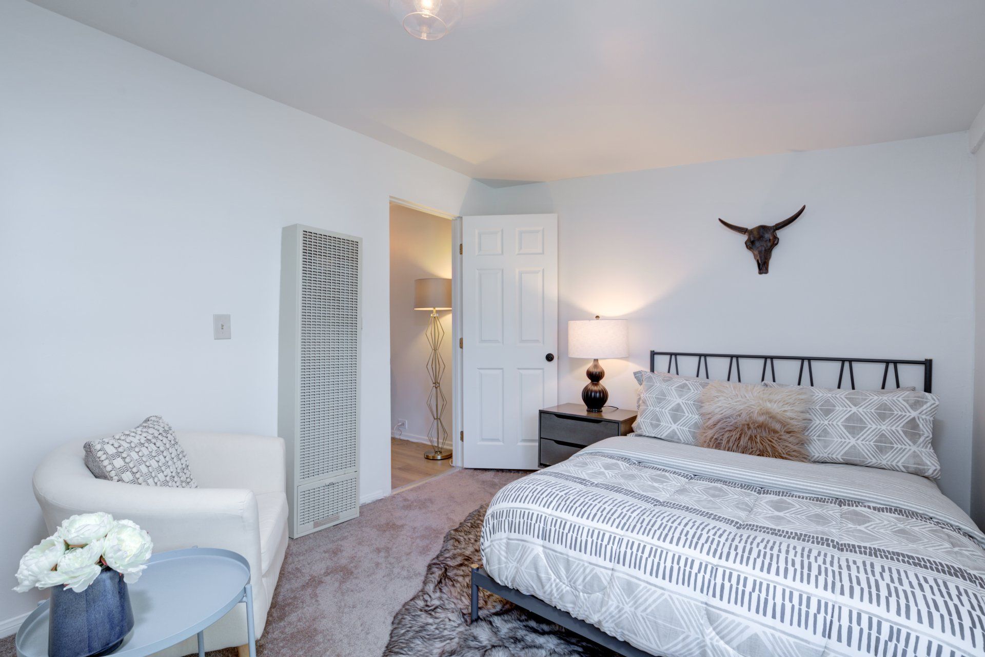 A bedroom with a bed , chair and nightstand