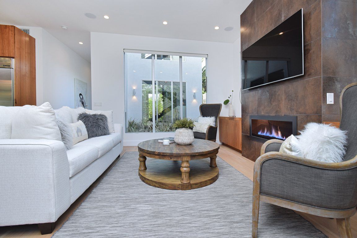 A living room with a couch , chair , coffee table and fireplace.