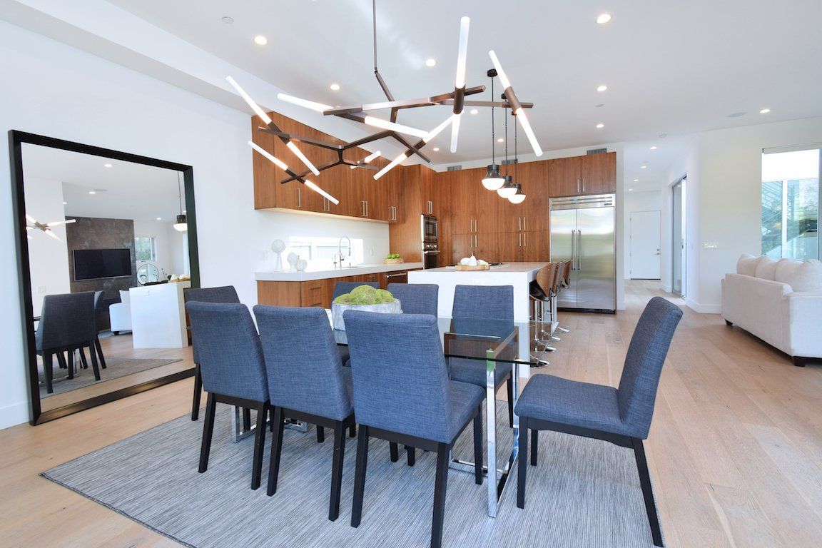 A dining room with a table and chairs and a large mirror