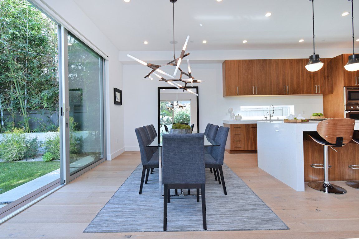 A dining room with a table and chairs and a kitchen