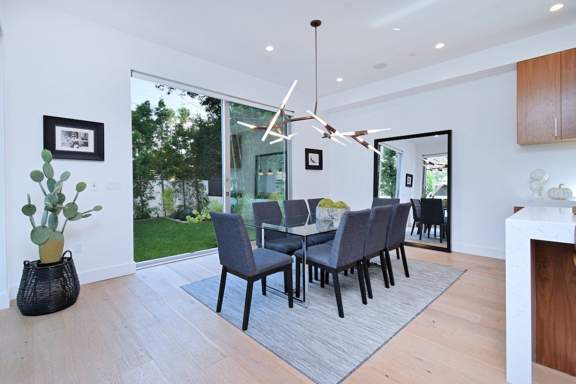 A dining room with a table and chairs and a large window