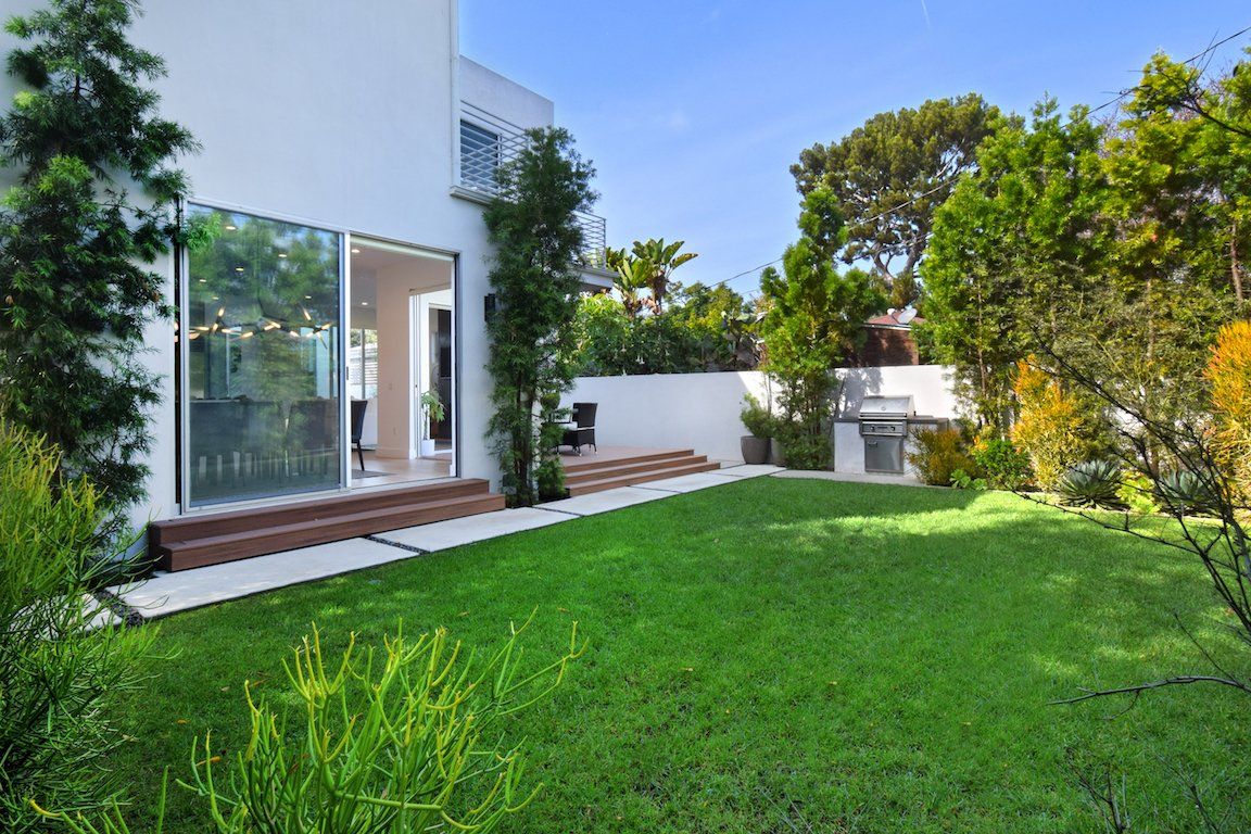 A white house with a large lawn in front of it.