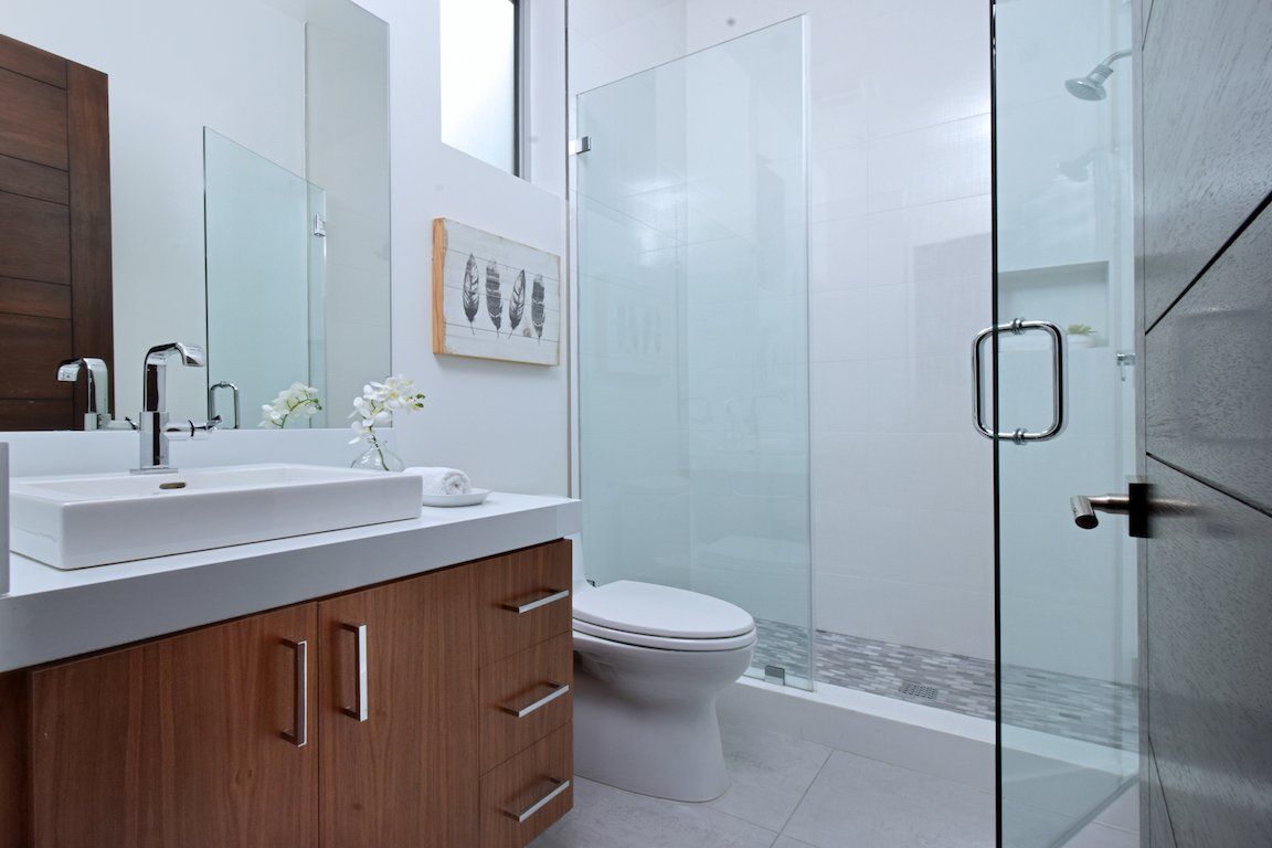 A bathroom with a sink , toilet and walk in shower.