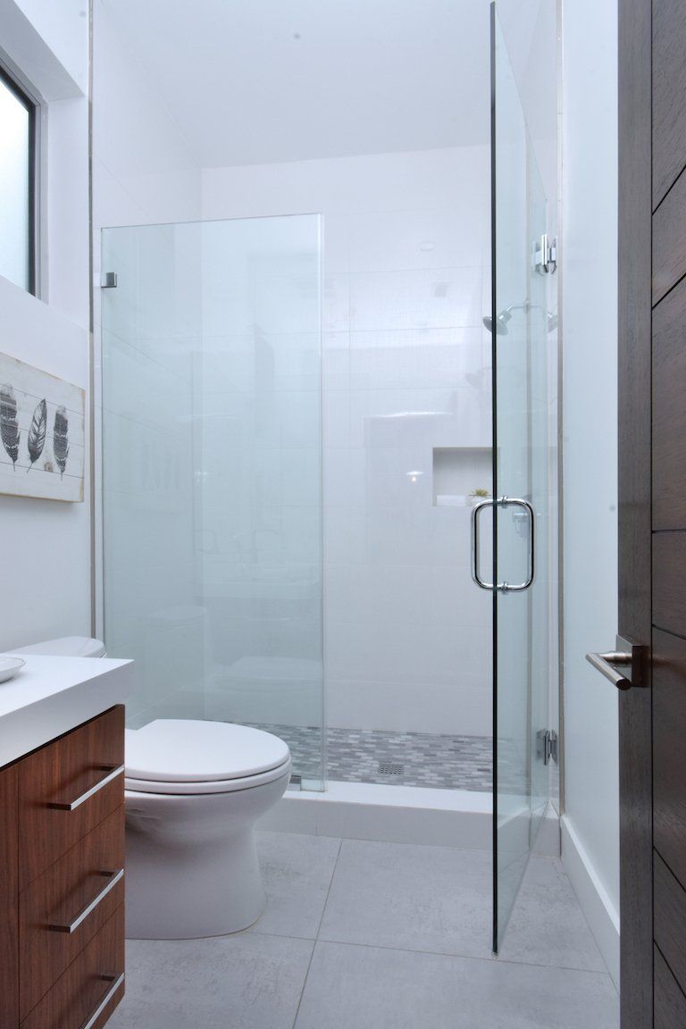 A bathroom with a toilet and a walk in shower