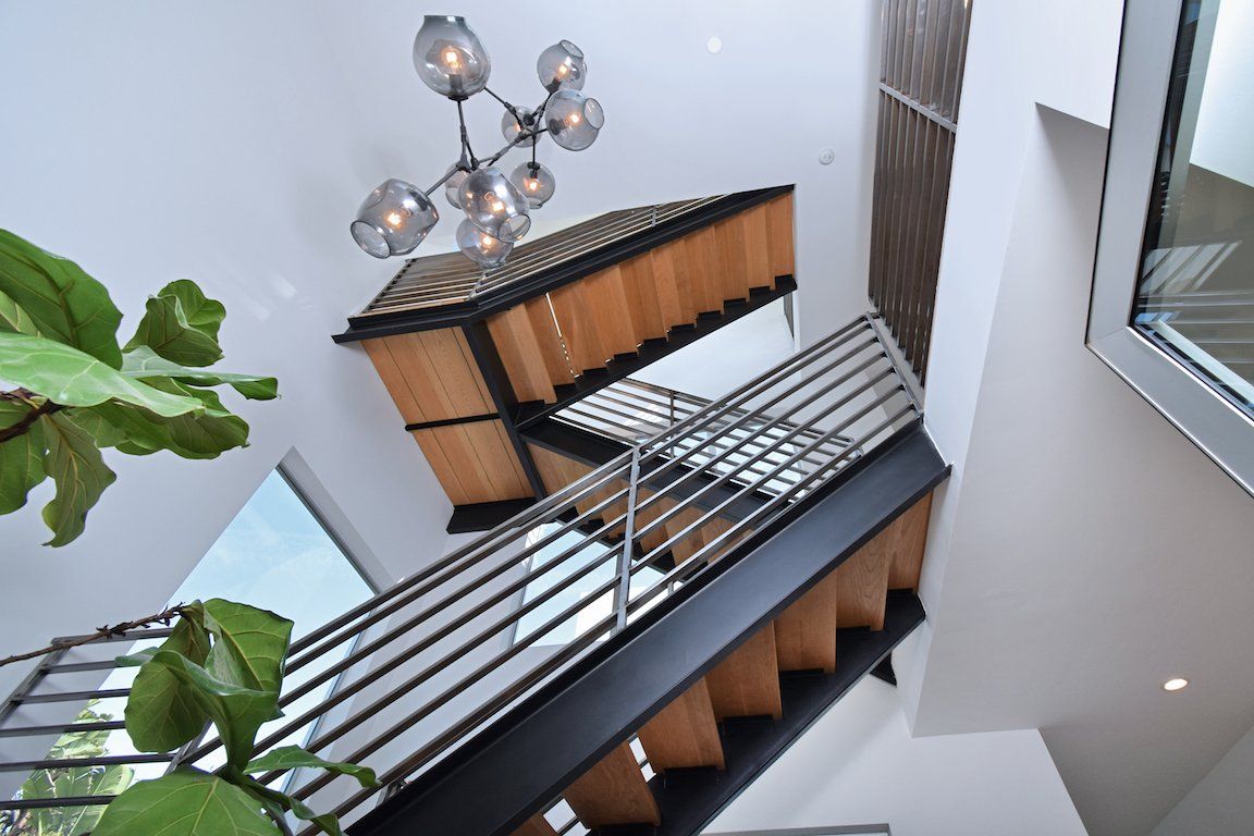 Looking down at a staircase with a chandelier hanging from the ceiling