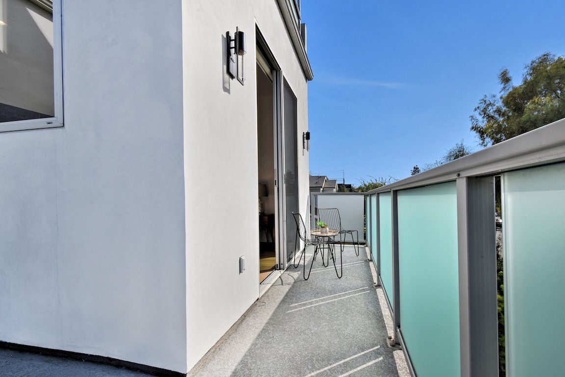 There is a balcony with a table and chairs on it.