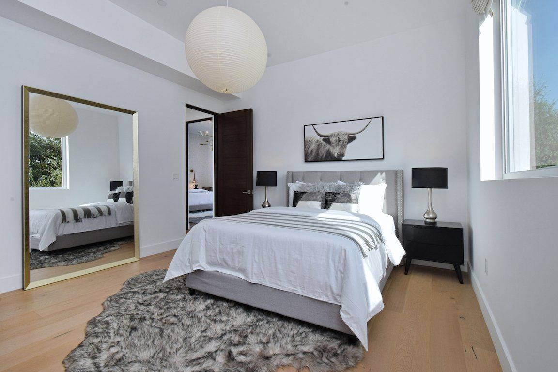 A bedroom with a large bed and a large mirror.