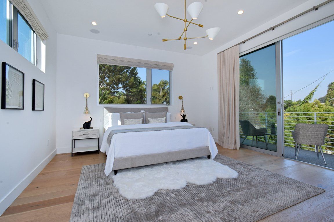 A bedroom with a large bed and sliding glass doors