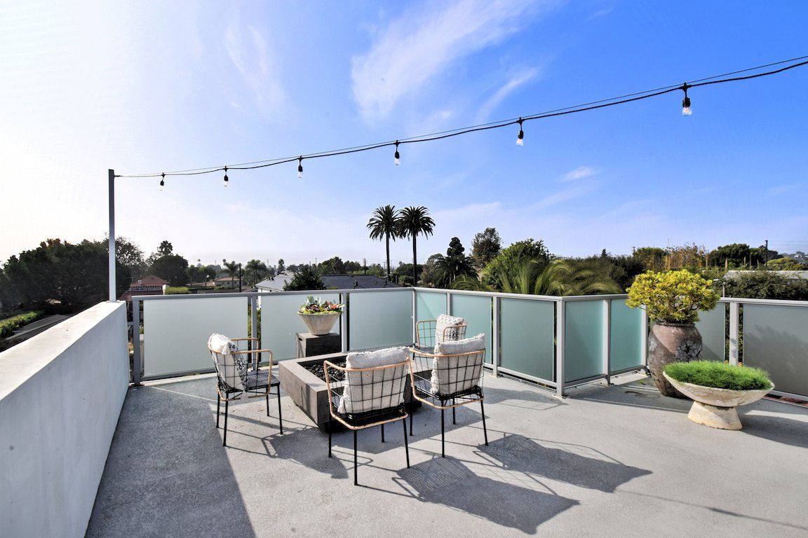 A balcony with a table and chairs and a fire pit.