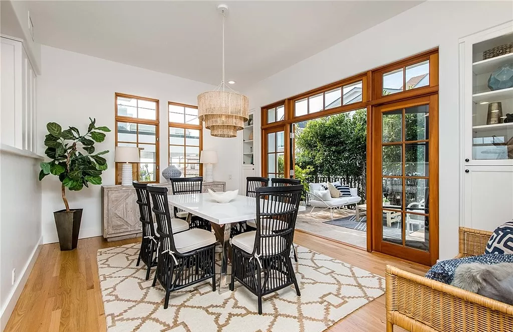 A dining room with a table and chairs and a rug.