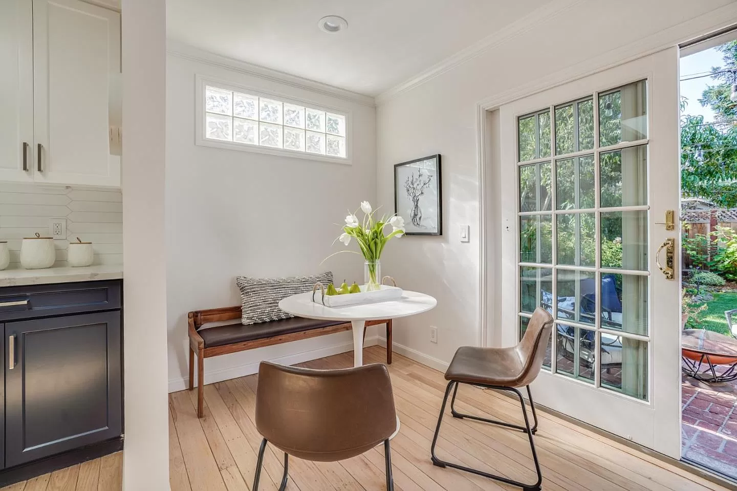 A dining room with a table and chairs and a bench.