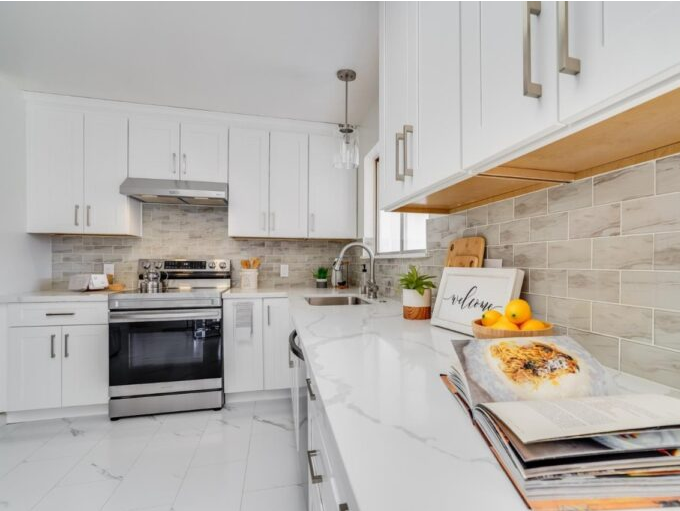 A kitchen with white cabinets and stainless steel appliances
