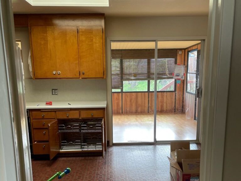 A kitchen with wooden cabinets and sliding glass doors