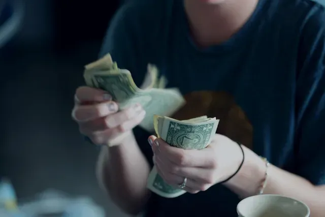 A woman is holding a bunch of money in her hands.