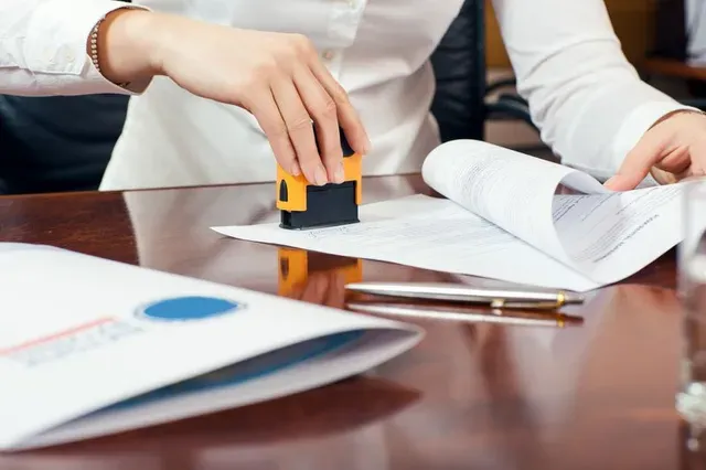 A person is putting a stamp on a piece of paper.