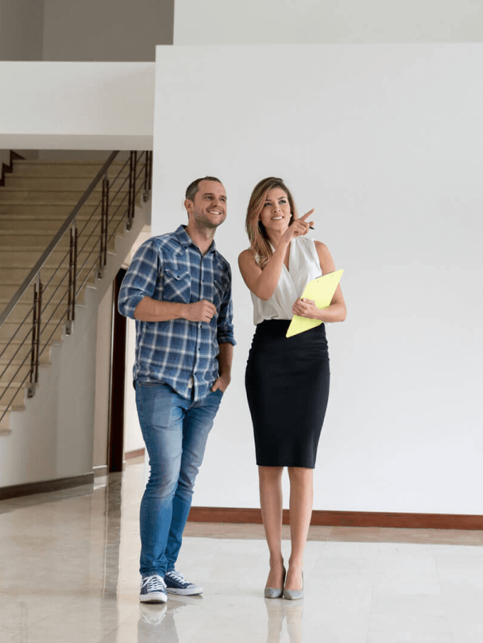 A man and a woman are standing next to each other in an empty room.