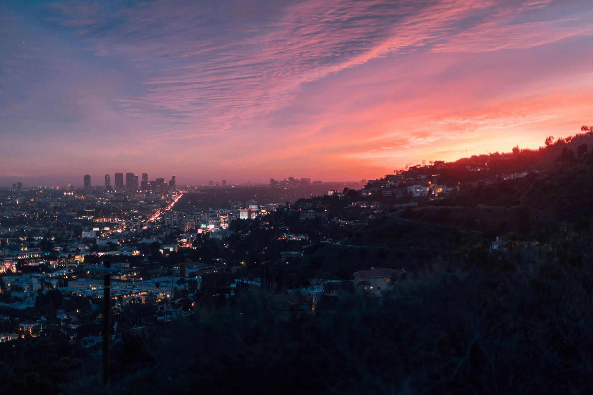 A view of a city at sunset from a hill.