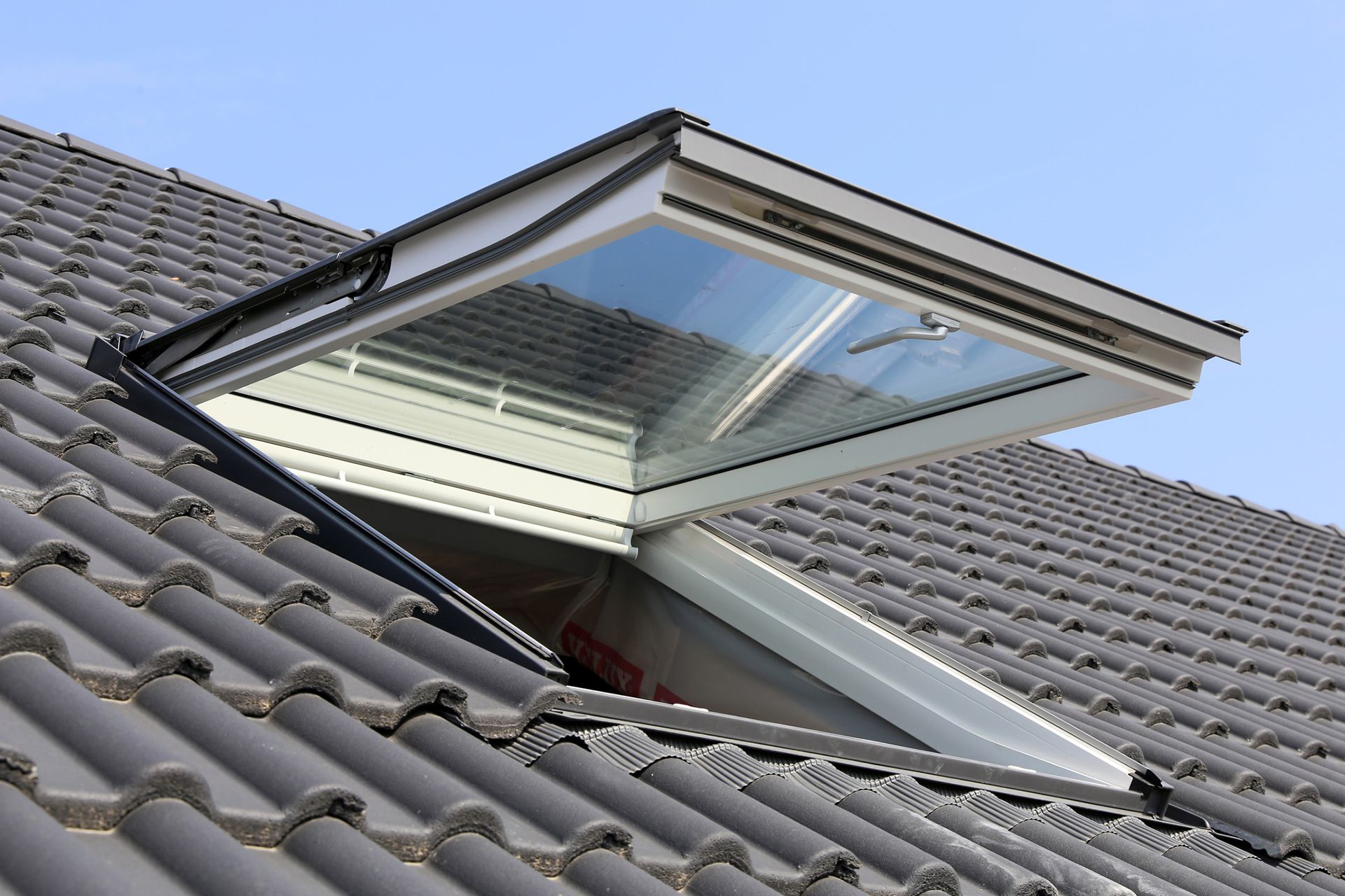 A skylight is open on the roof of a house