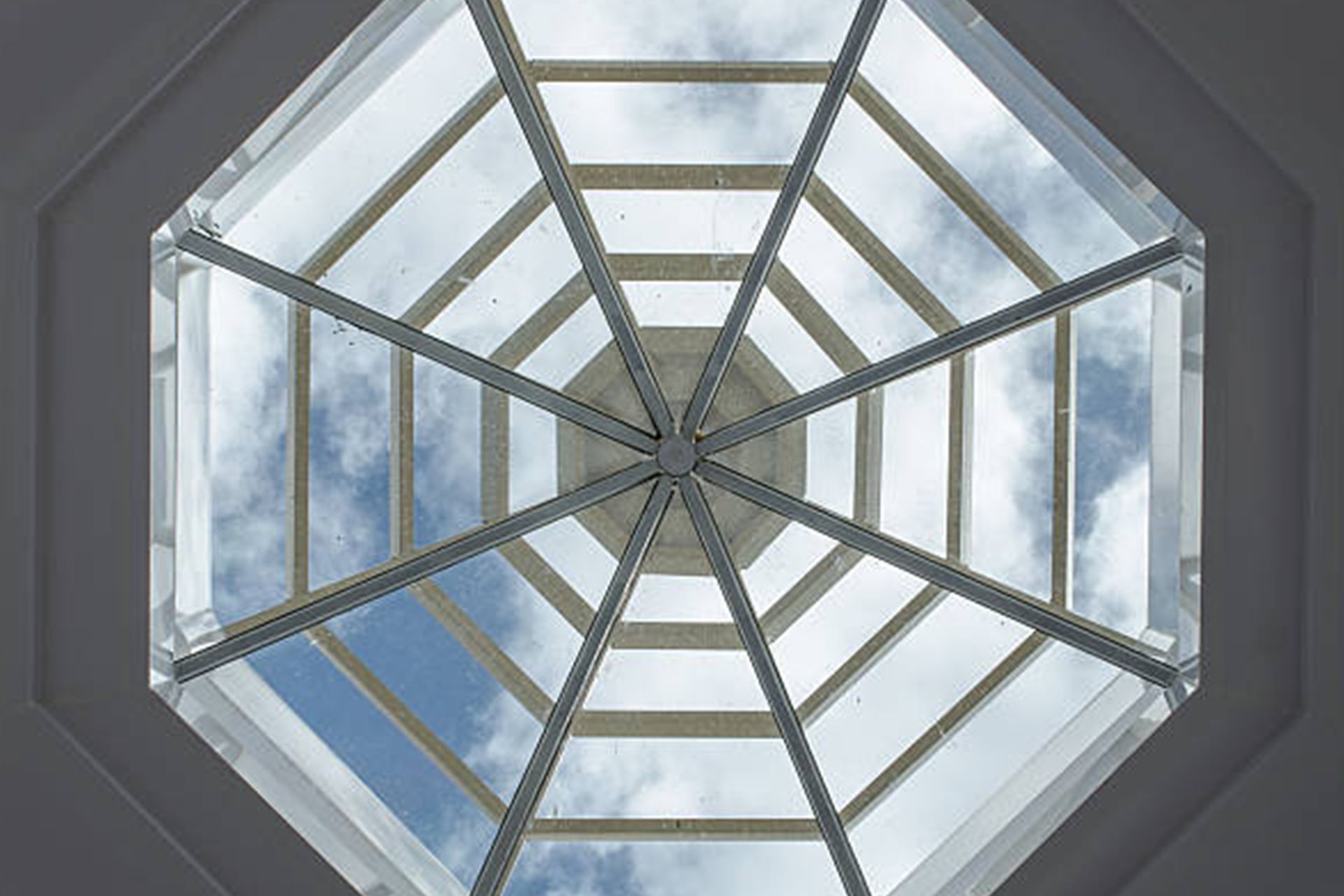 Looking up at the sky through a spider web shaped skylight