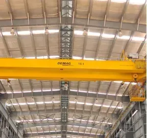 A large yellow crane is hanging from the ceiling of a building.