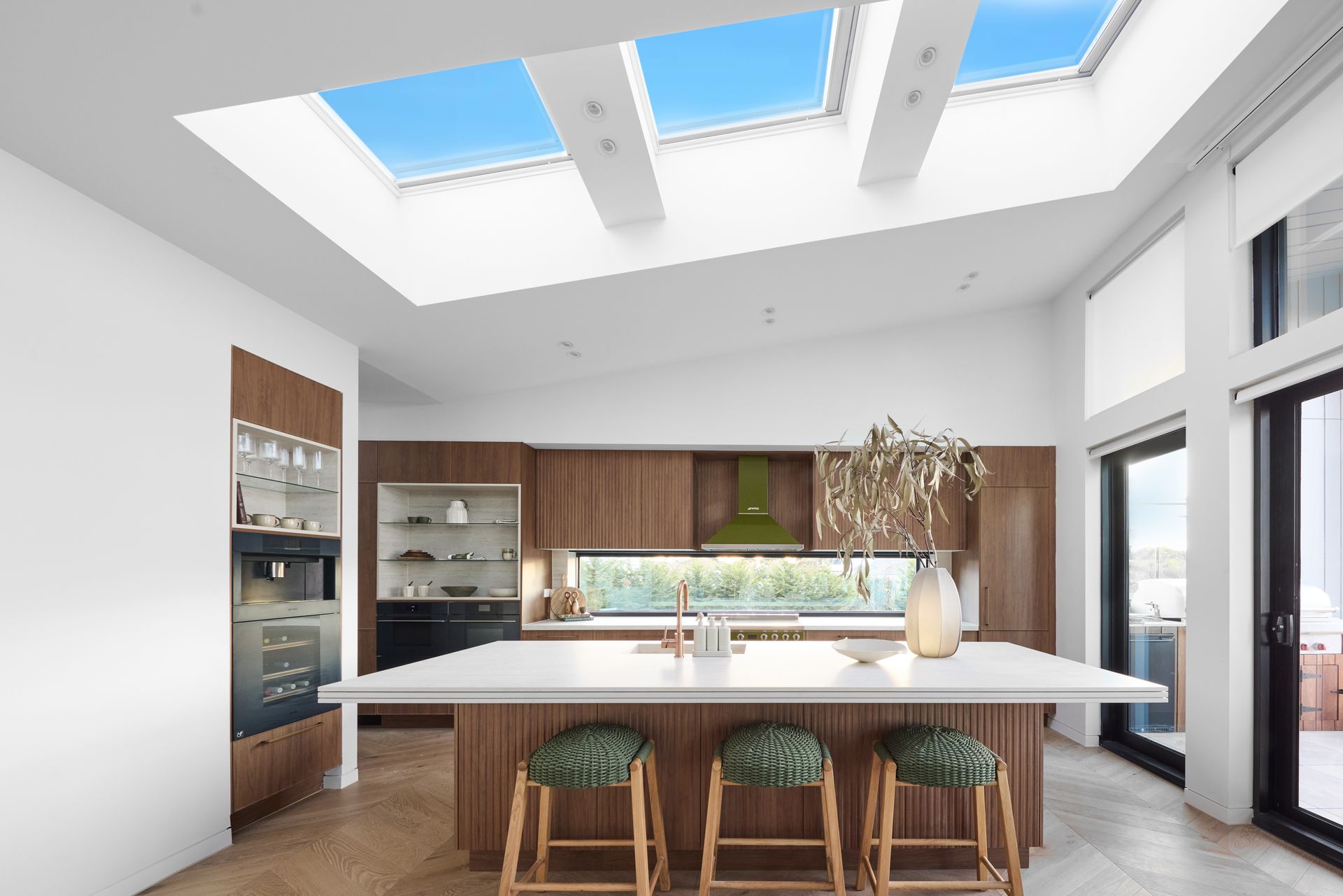 A kitchen with a large island and skylights above it.