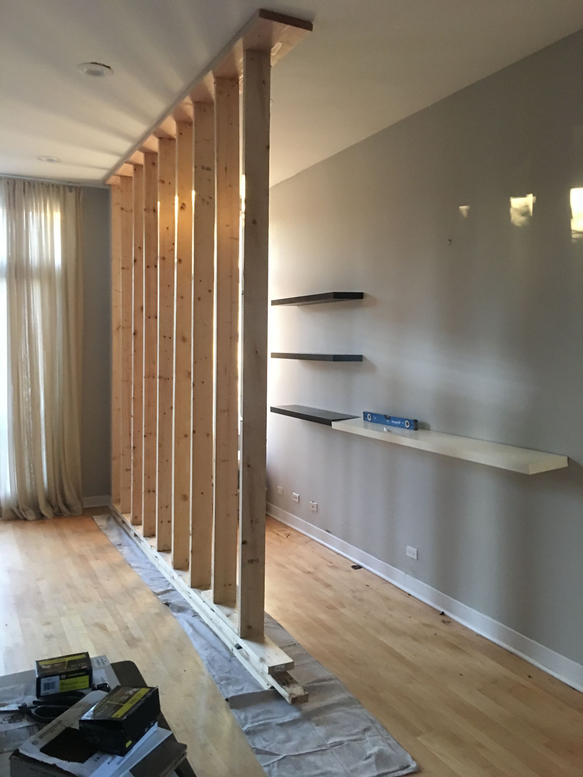Support wall built inside condo living room to hold up roof.