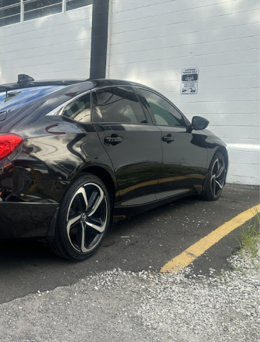 A black honda accord is parked in a parking lot next to a building - In Stock Auto Outlet & Collision