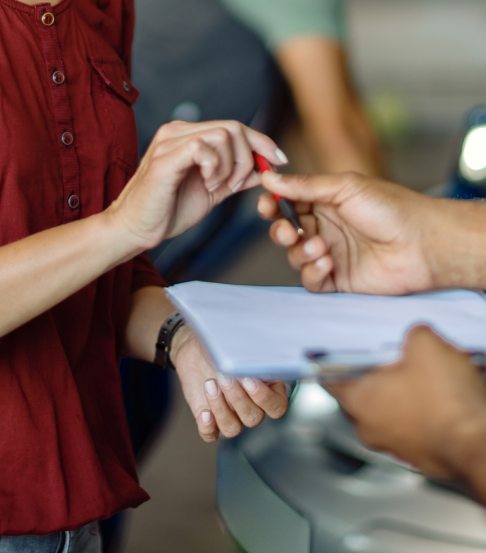 Holding a clipboard and a pen | In Stock Auto Outlet and Collision