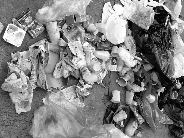 A black and white photo of a pile of trash on the ground.