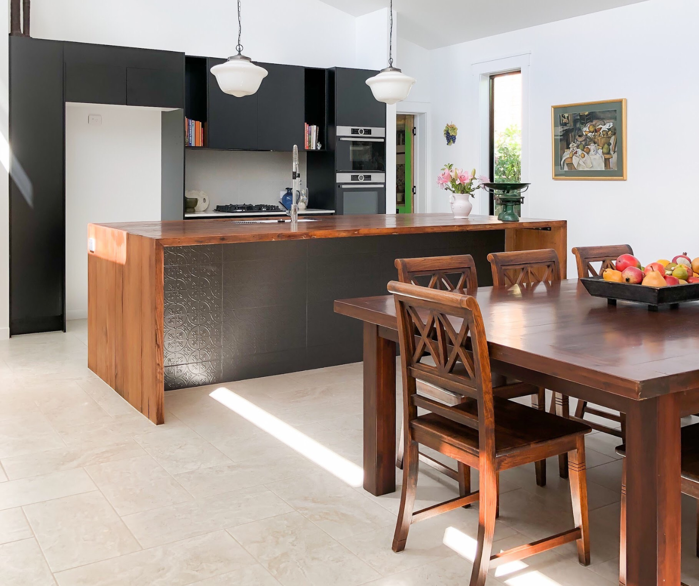 Modern kitchen and dining area with dark island, wood table, and pendant lights, bright and airy. Modern kitchen and dining area with dark island, wood table, and pendant lights, bright and airy.