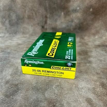 Box of Remington Core-Lokt 25-06 ammunition, green and yellow, on a brown surface.