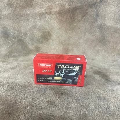 Red box of Norma TAC-22 .22 LR subsonic ammunition, set against a brown background.