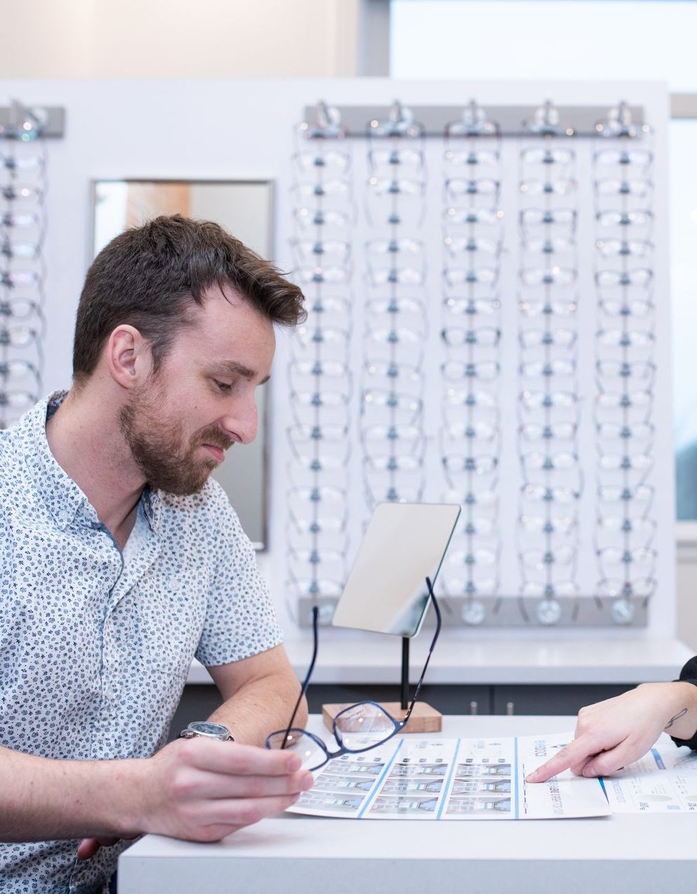 man choosing prescription glasses