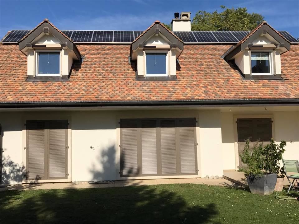 Une maison avec volets et panneaux solaires sur le toit réalisé par la société Laurent/Carvalho Sàrl