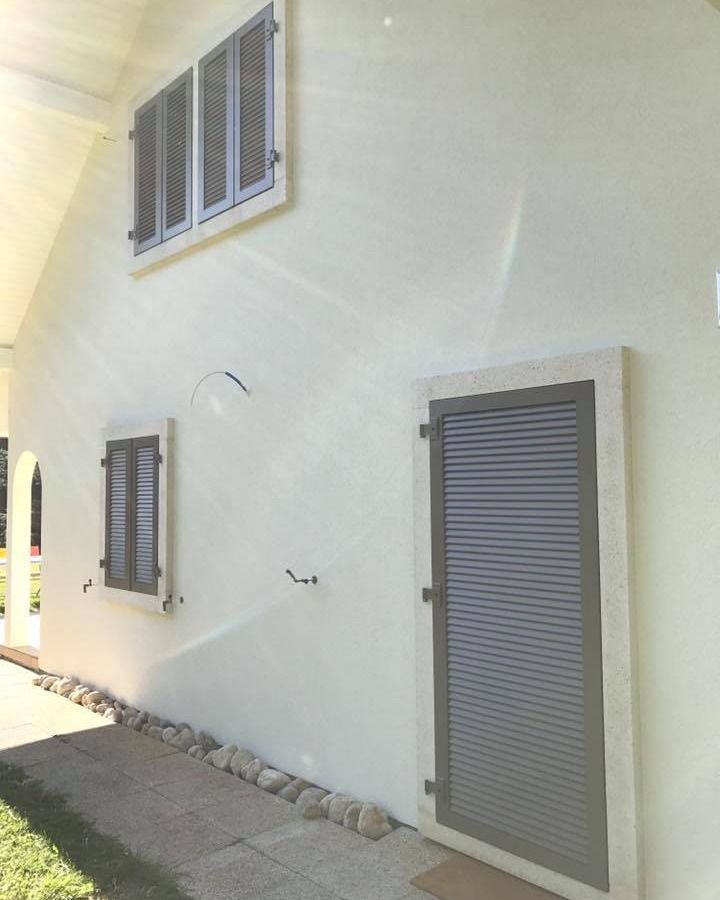 Une maison blanche avec des volets aux fenêtres réalisé par la société Laurent/Carvalho Sàrl