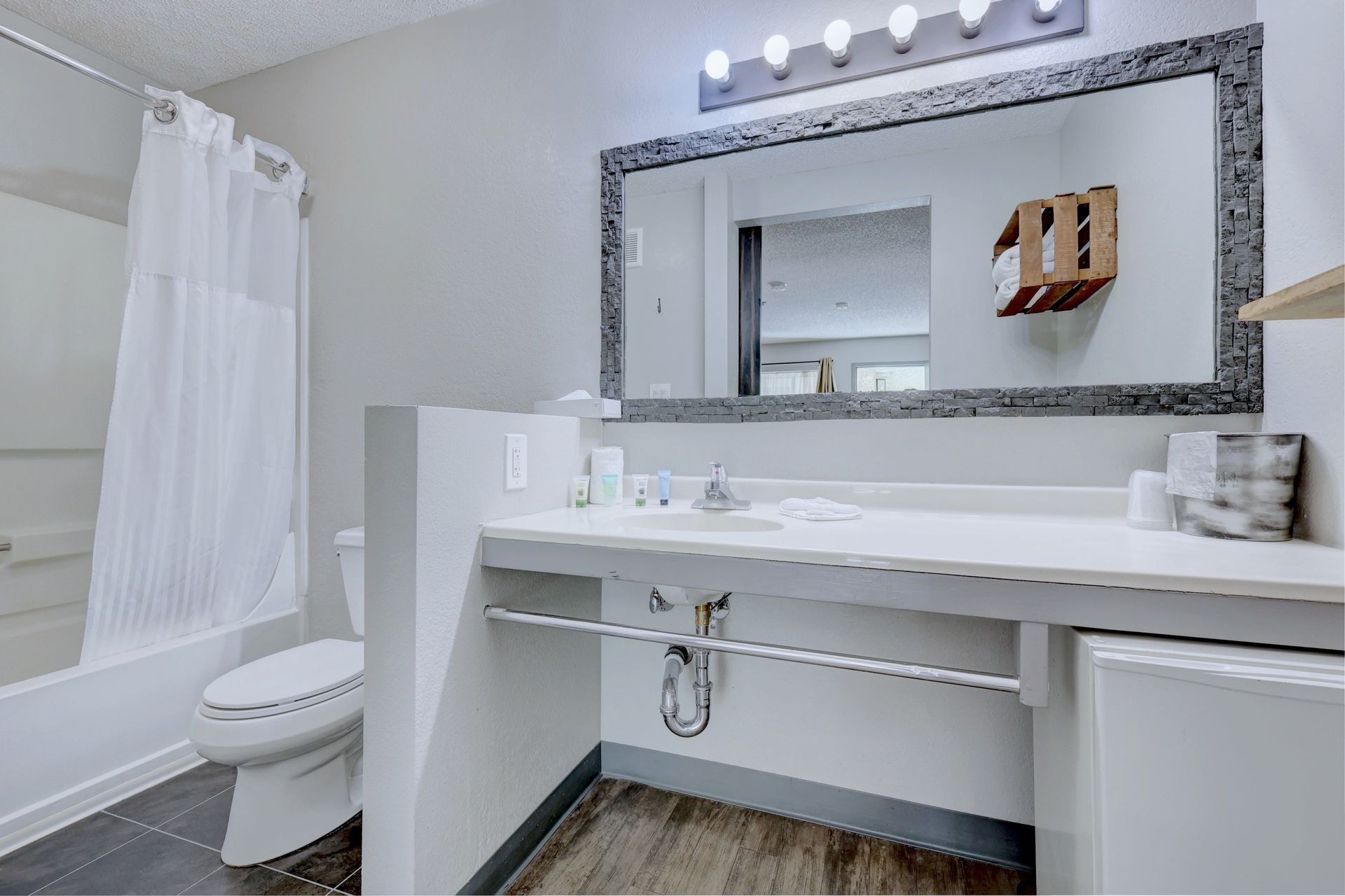 A bathroom with a toilet , sink , and mirror.