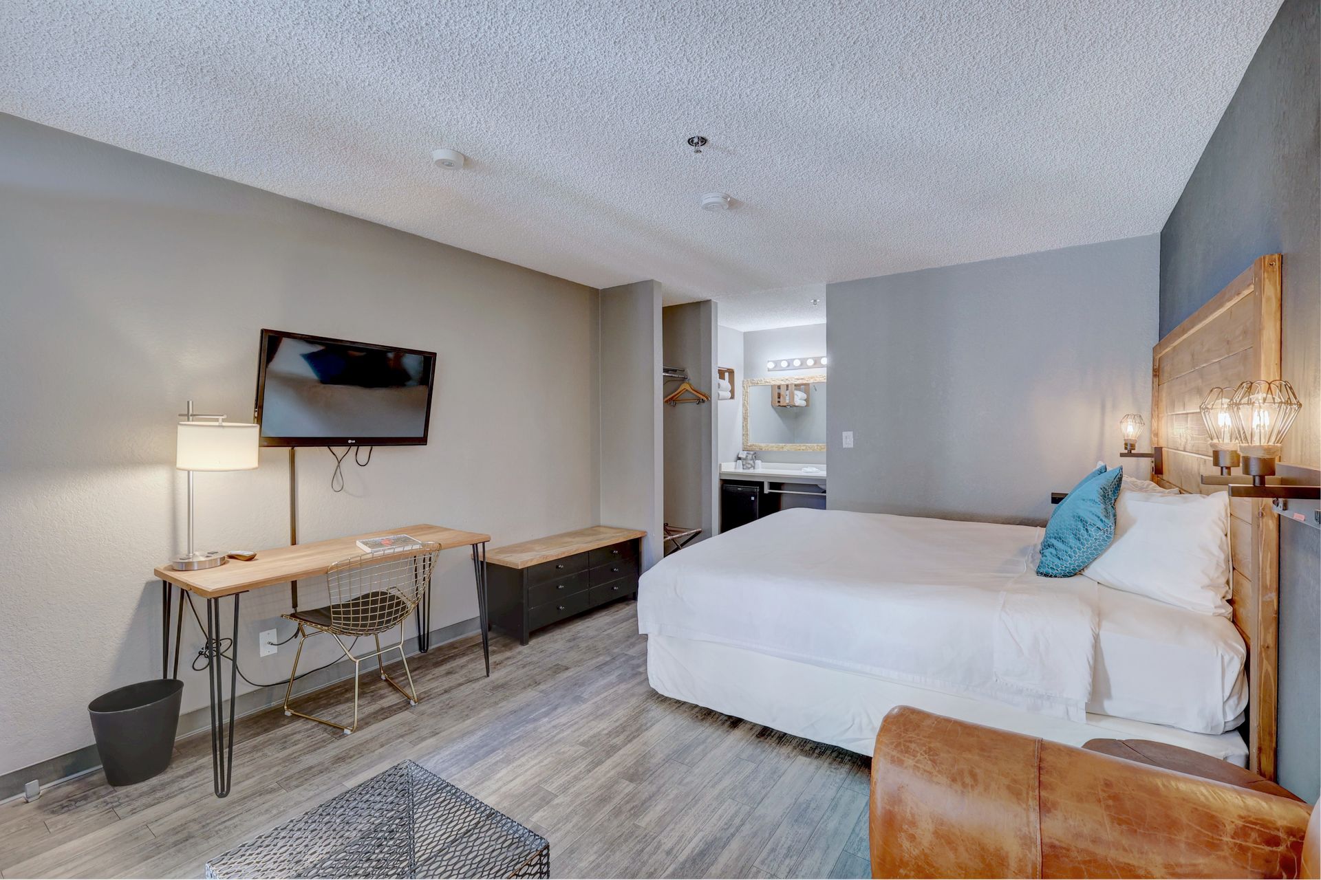 A hotel room with a king size bed , desk and television.