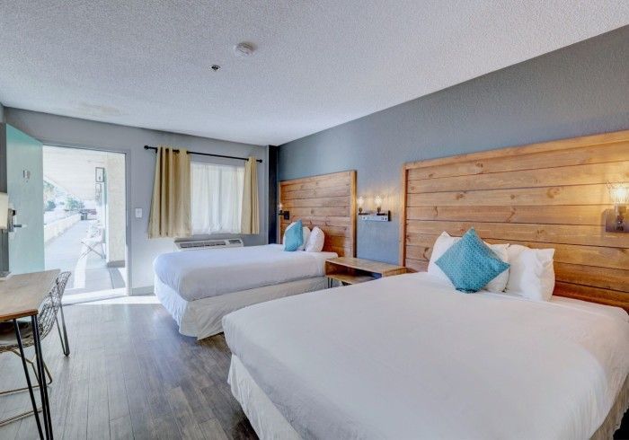 A hotel room with two beds and a desk.